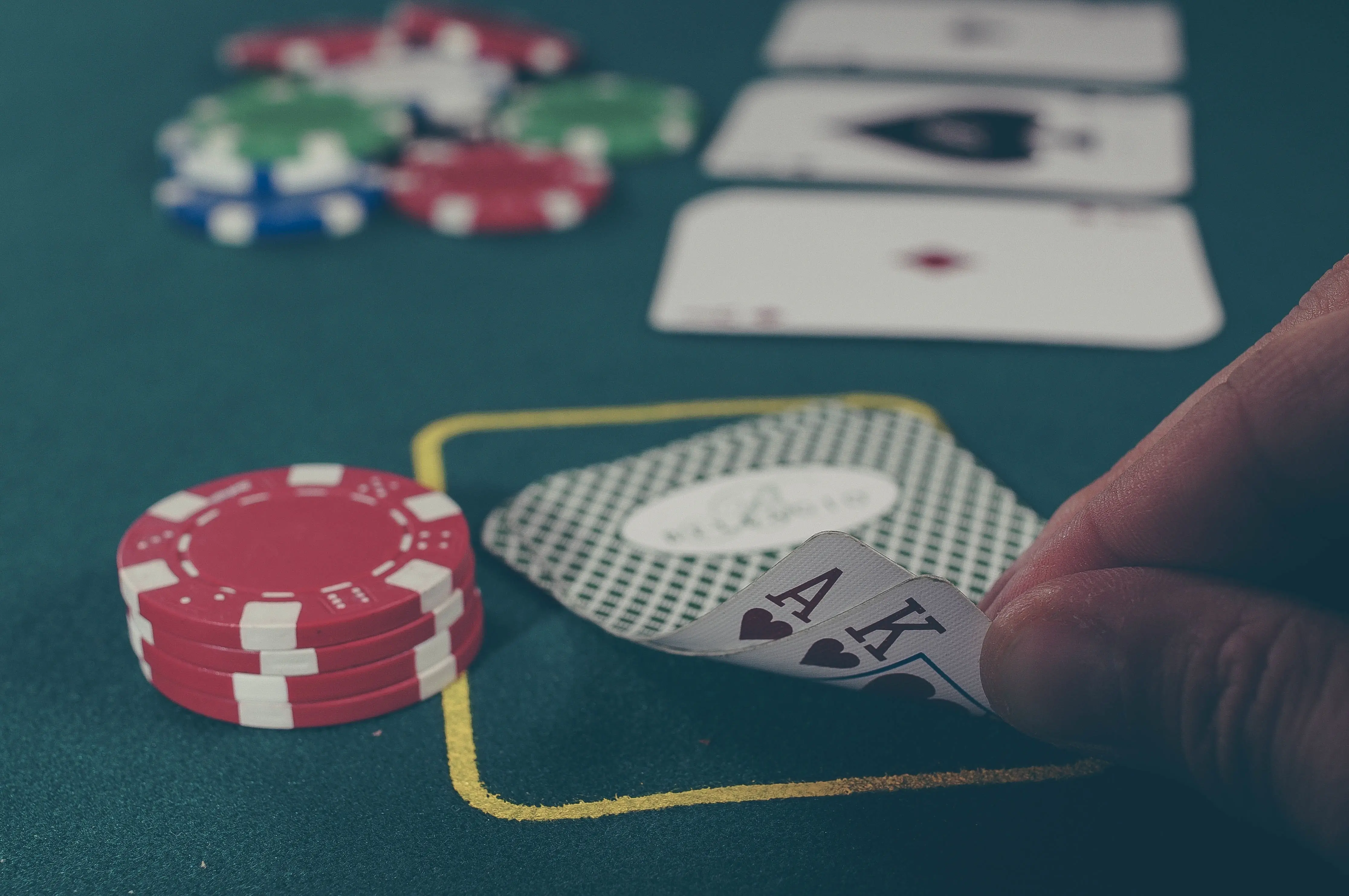Jogador de Poker a Verificar as suas cartas em jogo presencial